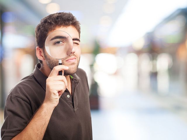 Estudiante analizando ofertas de trabajo con una lupa